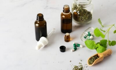 Herbal medicine bottles, capsules, and dried herbs on table